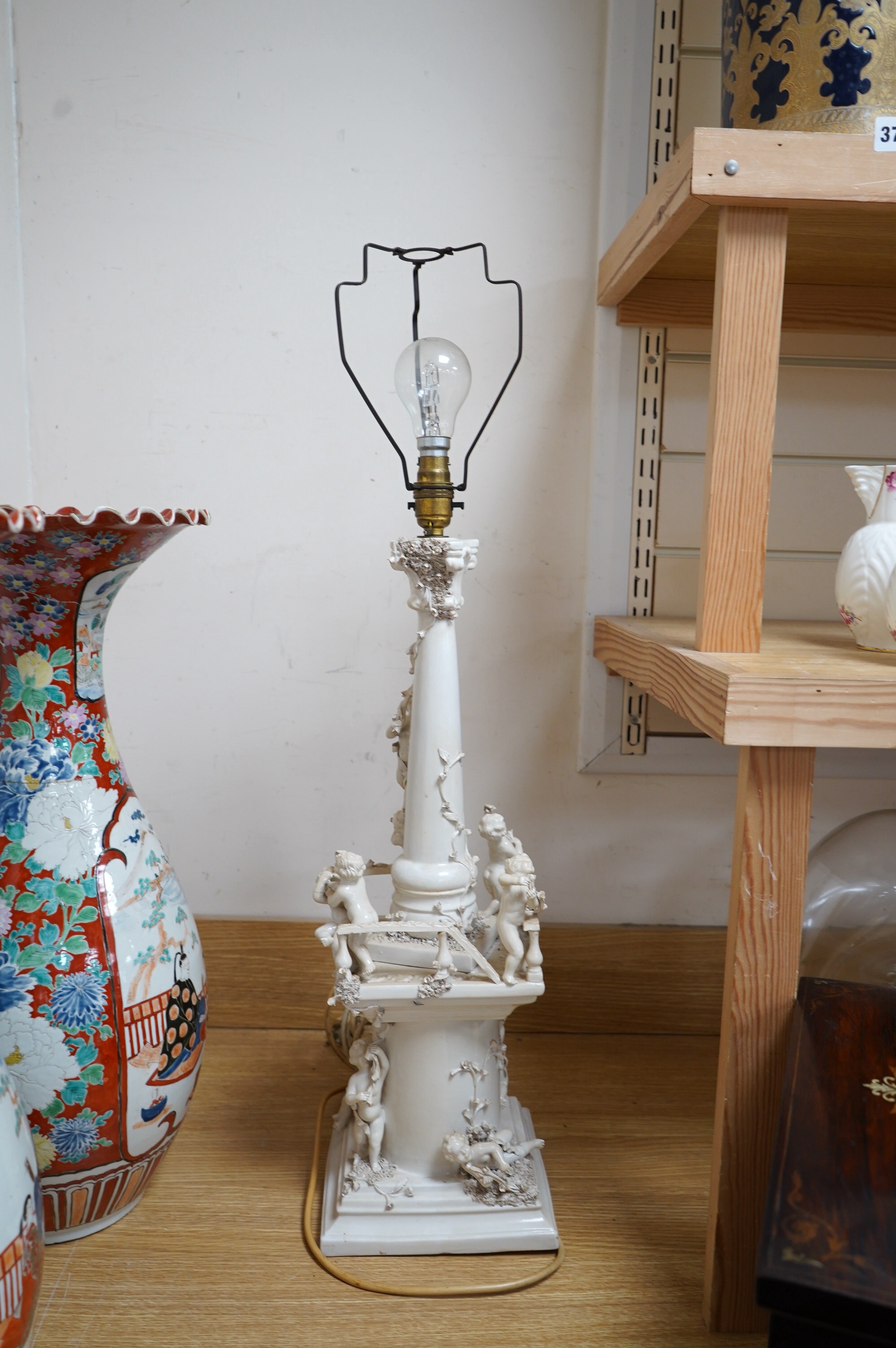 A modern Italian white maiolica ‘playing putti’ table lamp, 55cm. Condition - fair